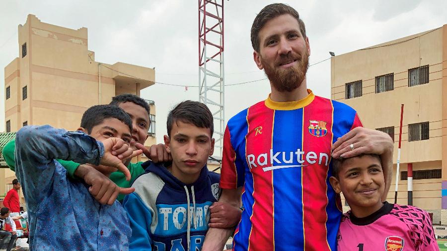 Ibrahim Battah, um egípcio com uma notável semelhança com o atacante do Barcelona Lionel Messi, posa para uma fotografia com meninos, na cidade de Zagazig, no Egito. - REUTERS/Sherif Fahmy