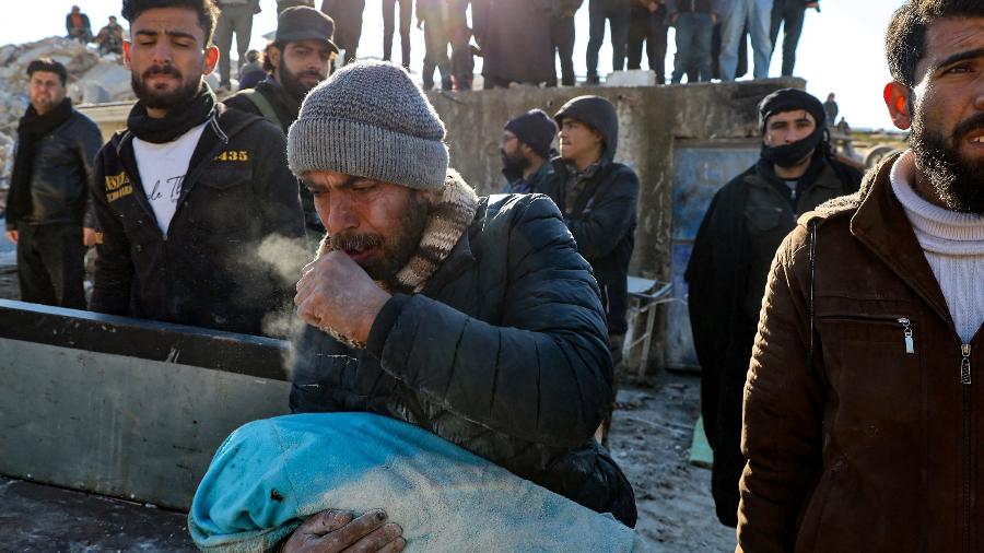 Em Harim, na Síria, homem resgata corpo de bebê de escombros após terremoto que atingiu o país e a Turquia - MOHAMMED AL-RIFAI/AFP