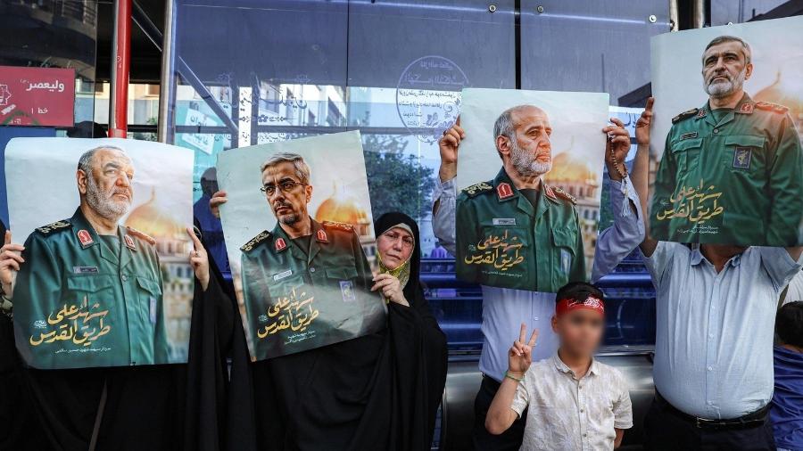 Mulher e criança aparecem ao lado de fotos de líderes militares mortos no Irã; da esquerda para a direita: Hossein Salami, Mohammad Bagheri, Gholam Ali Rashid e Amir Ali Hajizadeh Mulher e criança aparecem ao lado de fotos de líderes militares mortos no Irã; da esquerda para a direita: Hossein Salami, Mohammad Bagheri, Gholam Ali Rashid e Amir Ali Hajizadeh