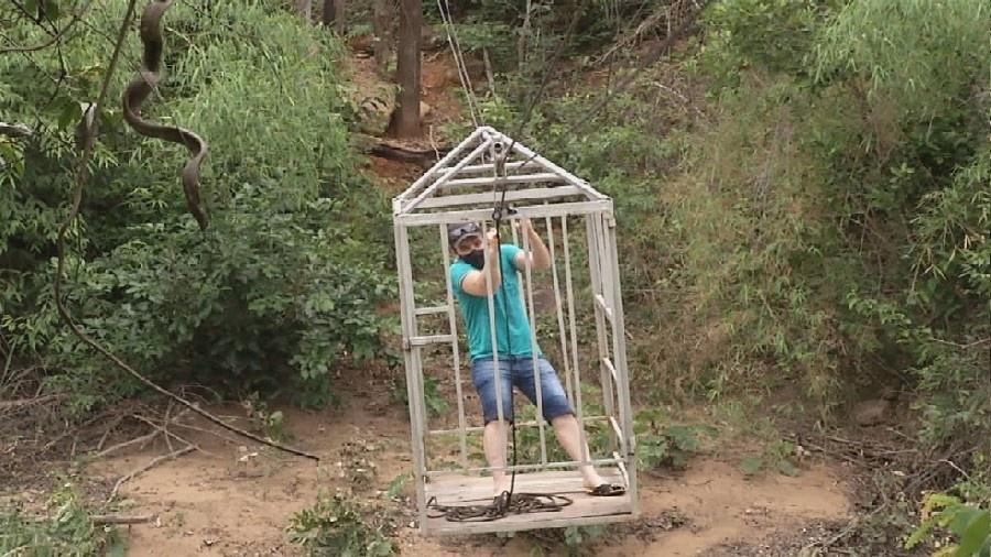 Homem atravessa córrego dentro de uma gaiola no interior de Goiás - Reprodução/TV Anhanguera