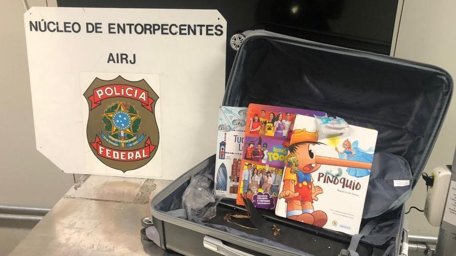 13.mar.2022 - Droga foi encontrada em livros infantis e no fundo falso de uma mala - Divulgação/Polícia Federal