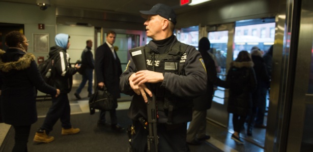 Policial observa pessoas saindo de local próximo à uma explosão que ocorreu no Terminal de ônibus da Port Authority, em Manhattan, Nova York - BRYAN R. SMITH/AFP