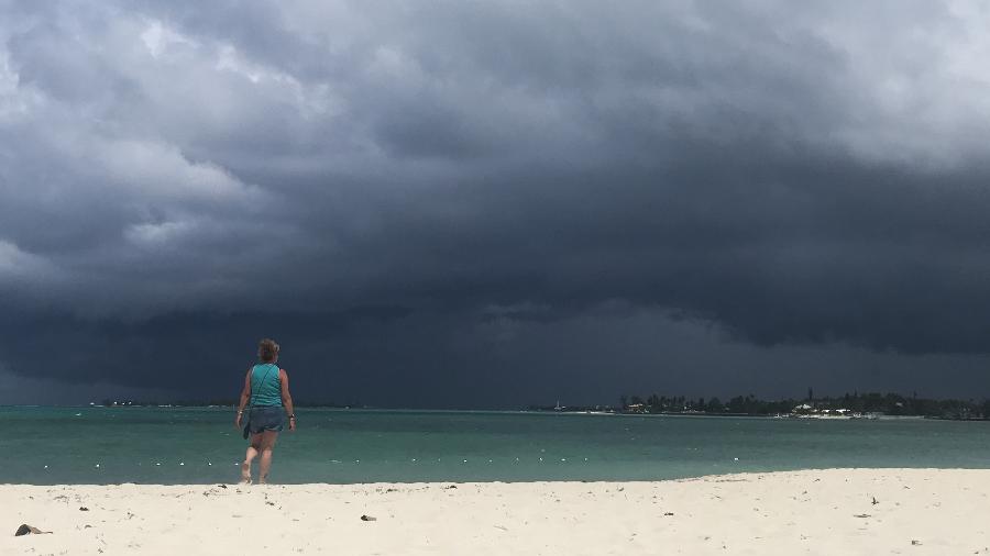 12.set.2019 - Mulher caminha na praia enquanto tempestade se aproxima em Nassau, nas Bahamas - Andrew Caballero-Reynolds/AFP