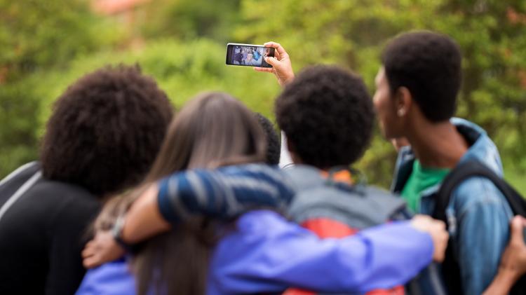 Jovens tiram selfie usando smartphone