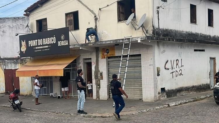 Policiais retiram câmera instalada fora de casa no bairro Joaquim Romão, em Jequié (BA)