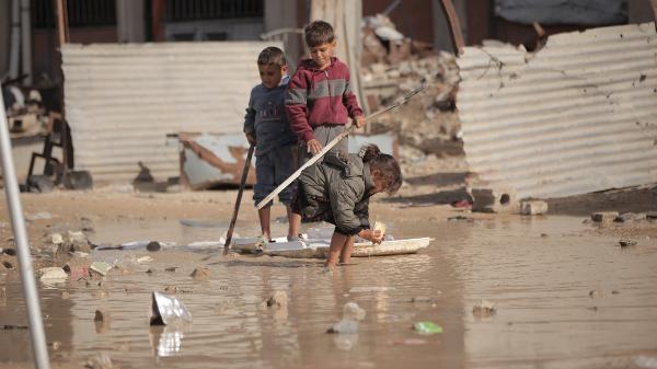 Crianças brincam nas ruas alagadas de Tel Al-Hawa após fortes chuvas, em Gaza