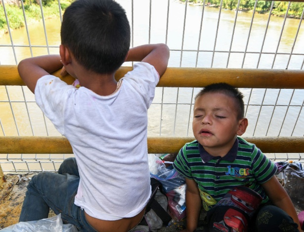 22.out.2018 - Crianças hondurenhas que integram a caravana que tenta chegar aos Estados Unidos esperam para cruzar a fronteira de Ciudad Tecun Uman, na Guatemala, para Ciudad Hidalgo, Mexico - ORLANDO SIERRA/AFP