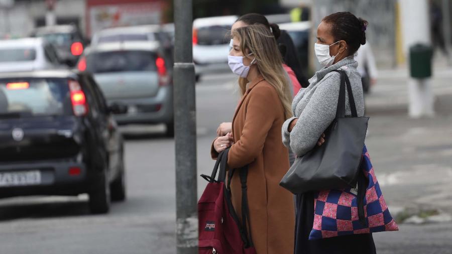 Pedestres se protegem do frio após chegada de frente fria na cidade de São Paulo