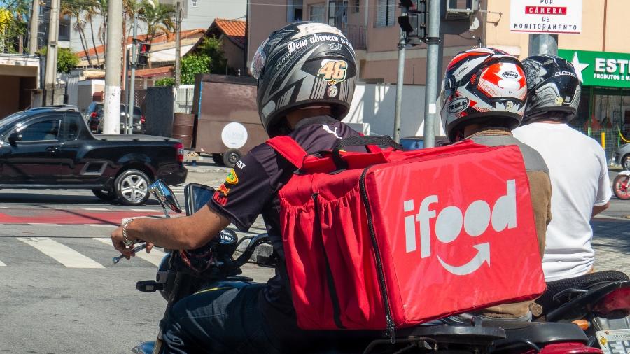 Motociclista com mochila do iFood parado do trânsito - Getty Images