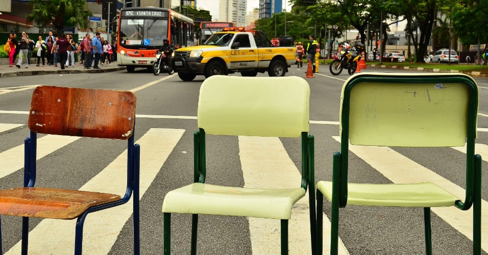 30.nov.2015 - Estudantes bloqueiam, com cadeiras e cartazes, um dos sentidos da Avenida Brigadeiro Faria Lima, em protesto contra a reorganização escolar no estado de São Paulo