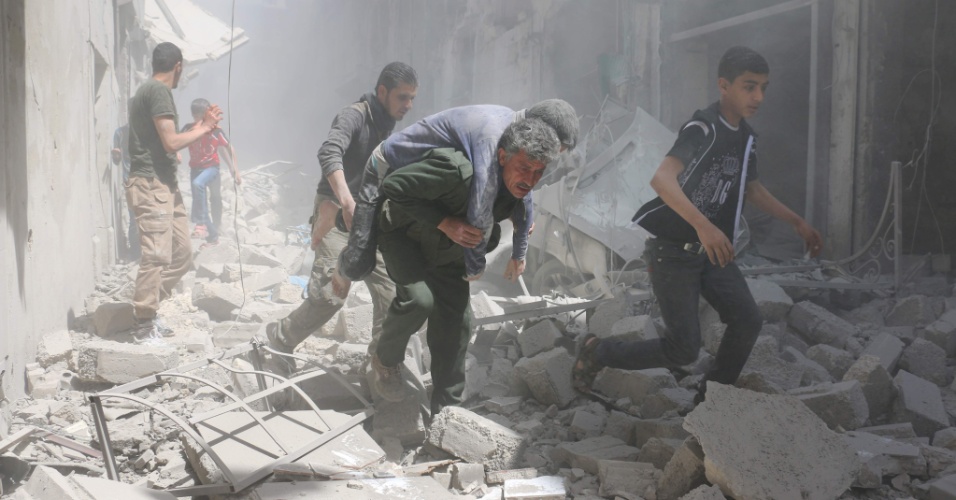 29.abr.2016 - Sírios avacuam edifícios destruídos na sequência de um ataque aéreo em bairro controlado pelos rebeldes da Al-Qatarji, em Aleppo, Síria. Um dia antes, o último médico pediatra que havia na região morreu depois de bombardeio num hospital da cidade 