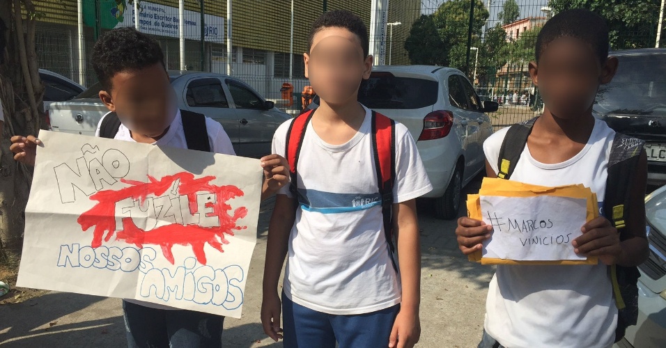 Estudantes exibem cartaz em protesto contra violência na favela