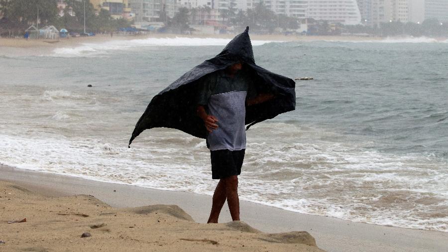 18.set.2019 - Homem se protege da chuva durante passagem do Lorena, em Acapulco, no México - Javier Verdin - 18.set.2019/Reuters