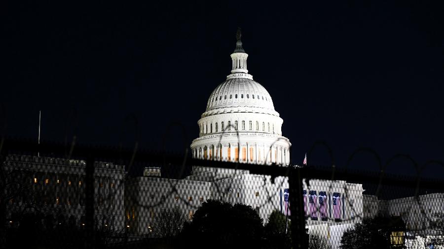 O Capitólio é retratado atrás de arame farpado e uma barricada antes da posse do presidente eleito dos EUA, Joe Biden, em Washington, EUA - Andrew Kelly/Reuters