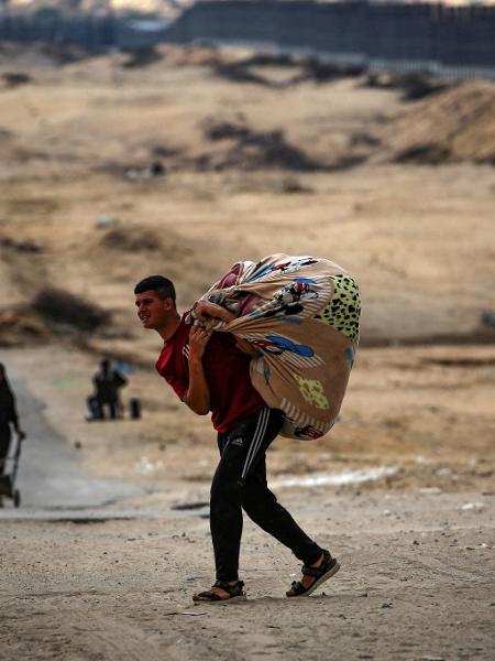 Os palestinos transportam os seus pertences enquanto se preparam para fugir de Rafah, no sul da Faixa de Gaza, em 13 de maio de 2024