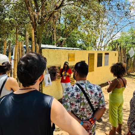 A guia turística Thaís Patrícia durante passeio com grupo de turistas no Parque Memorial Quilombo dos Palmares.