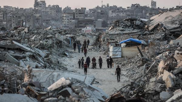 Palestinos caminham entre escombros em Jabalia, norte de Gaza 
