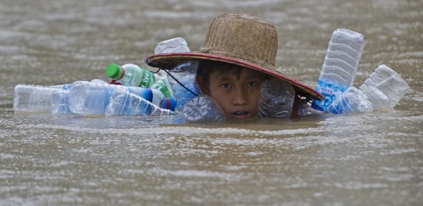 11.ago.2015 - Menino desabrigado pela enchente nada em rua alagada da vila Kyaut Ye, em Mianmar - Ye Aung/AFP