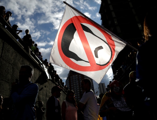 Manifestante seguram bandeira com desenho do presidente Nicolás Maduro durante protesto em Caracas, na Venezuela - Ueslei Marcelino/Reuters