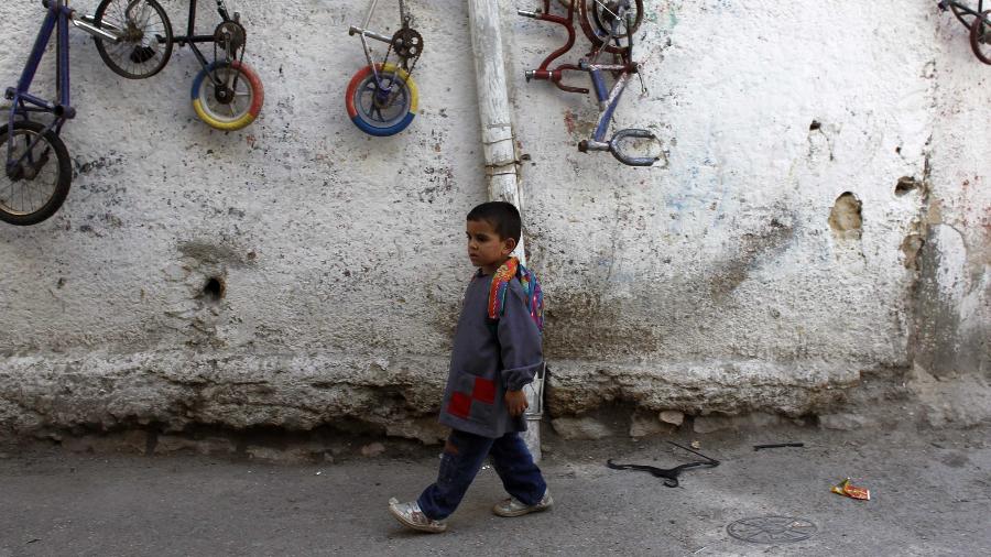 Menino palestino caminha no campo de refugiados al-Amari, na cidade de Ramallah, Cisjordânia - Reprodução