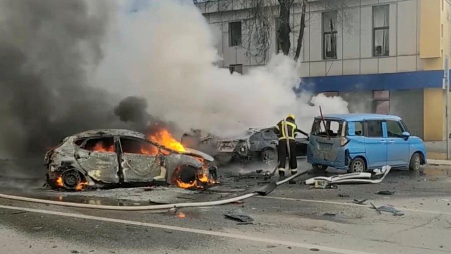 Bombeiro tenta apagar carro em chamas após um ataque de forças ucranianas à cidade de Belgorod