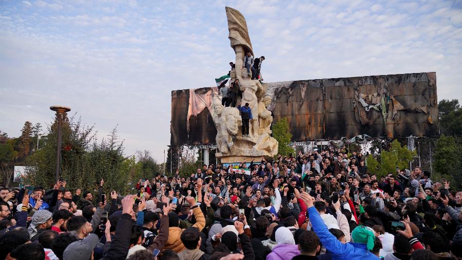 Pessoas comemoram o anúncio do fim do regime de Bashar al-Assad na Praça Saadallah al-Jabiri, na cidade de Aleppo