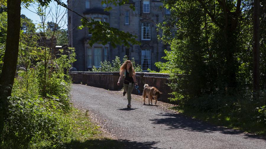 Jovem anda com seu cão na ponte Overtoun em Dumbarton, na Escócia - Sophie Gerrard for The New York Times