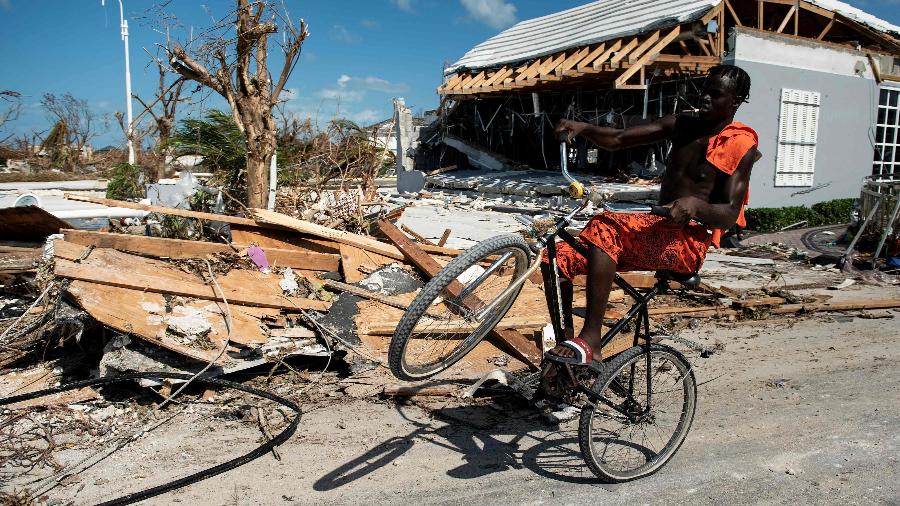 5.set.2019 - Homem pedala em área atingida pelo furacão Dorian nas ilhas Ábaco, nas Bahamas - Brendan Smialowski/AFP