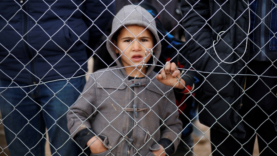 Criança iraquiana que fugiu do Estado Islâmico em Mossul observa da cerca do campo de refugiados Khazer, no Iraque - Ahmed Jadallah/ Reuters