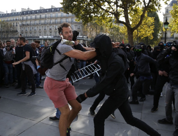 Manifestante tenta impedir grupo de mascarados de invadir um palanque durante protesto convocado por opositores das reformas trabalhistas propostas pelo governo francês - Zakaria Abdelkafi/AFP