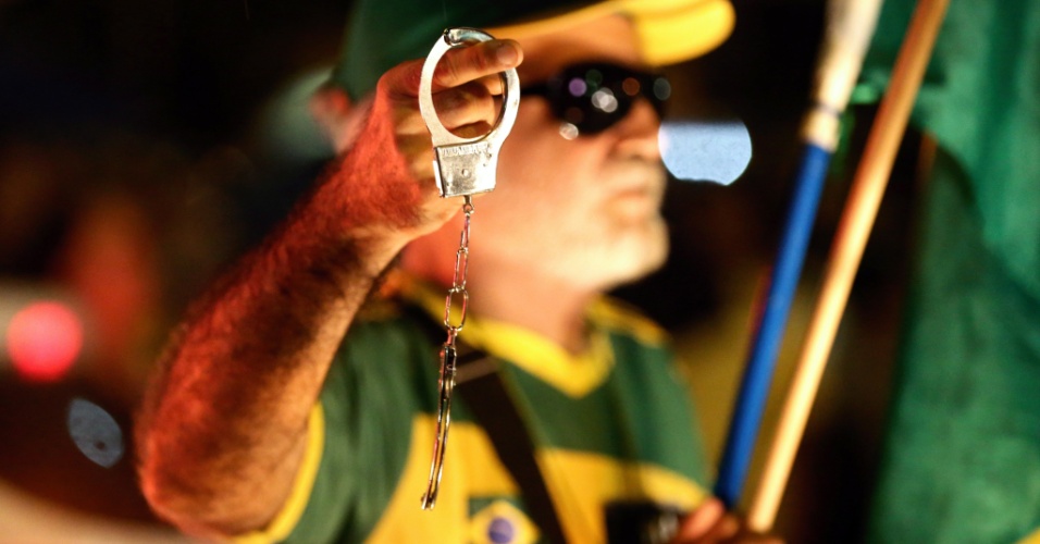 3.abr.2018 - Manifestante vestido de verde e amarelo exibe um par de algemas durante ato no Rio de Janeiro para pressionar o STF a não aceitar um recurso que busca evitar a prisão do ex-presidente Lula