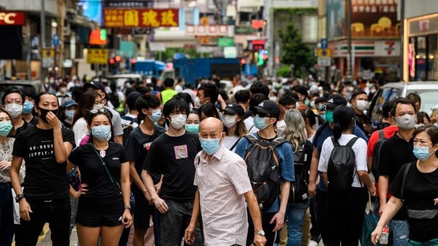 27.mai.2020 - Manifestantes olham na direção de um grupo de policiais de choque no bairro de Mongkok, em Hong Kong, enquanto a cidade debate uma lei que proíbe "insultar" o hino nacional. A polícia usou gás de pimenta e prendeu centenas de pessoas que protestavam - Anthony Wallace/AFP