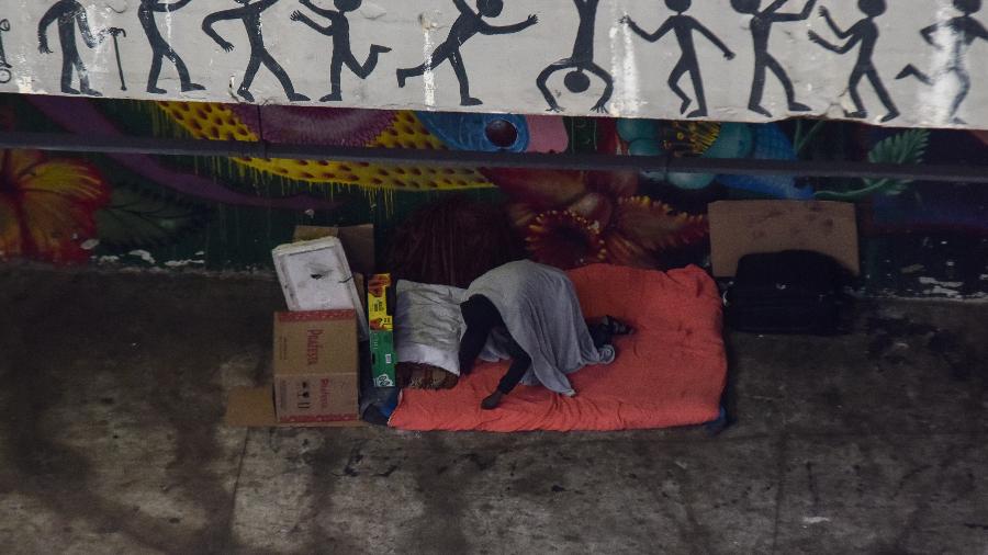 Pessoa em situação de rua, dorme em calçada, no Túnel José Roberto Fanganiello Melhem, na Av. Paulista - ROBERTO CASIMIRO/ESTADÃO CONTEÚDO
