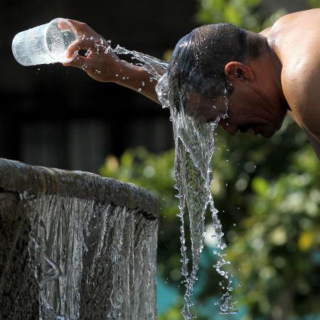 Homem se refresca em fonte de água no México; onda de calor deve se manter