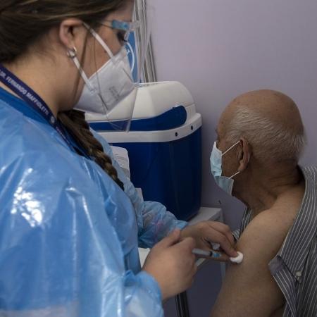 Arquivo - Trabalhadora da saúde aplica CoronaVac em idoso em Santiago; Chile é um dos países com maior percentual de população vacinada do mundo - Martin Bernetti/AFP