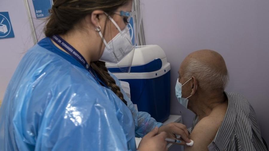 Trabalhadora da saúde aplica CoronaVac, vacina contra covid-19, em idoso em Santiago, no Chile - Martin Bernetti/AFP