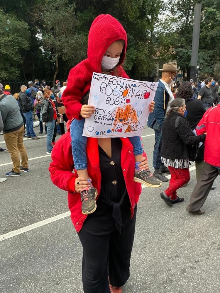 Maria Fernanda Uehara, 32, e a filha Tereza, 4, chamaram atenção com o cartaz feito por Tereza contra Bolsonaro. "Eu contei a situação para ela e perguntei o que ela queria dizer no cartaz. Ela disse várias coisas, a gente resumiu para caber. Ela falou que 'ele mente muito e todo mundo vai ficar bravo'. É o que ela mais entende que é errado", disse a mãe, que é professora - Anahi Martinho/UOL
