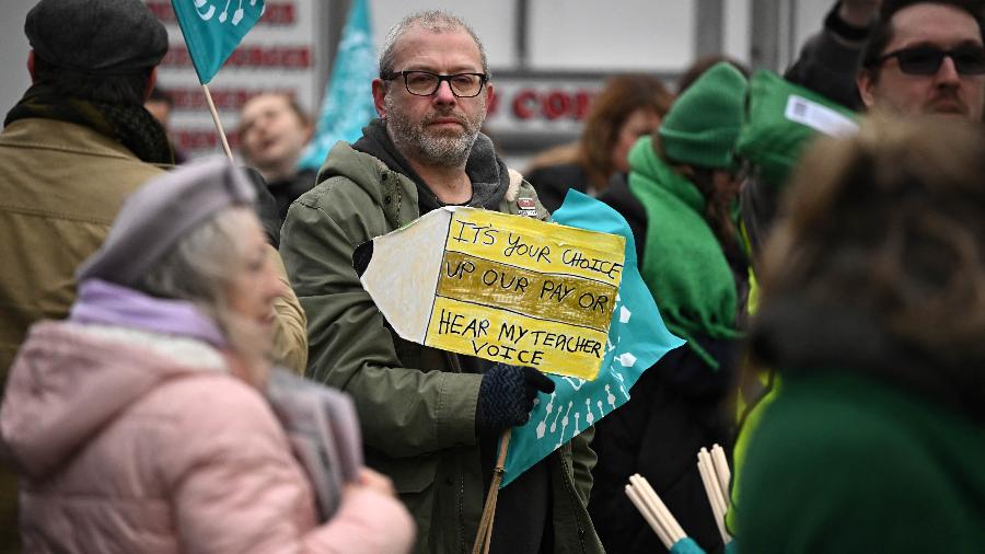 01.fev.23 - Um professor segura um cartaz durante uma manifestação organizada por sindicato do lado de fora da prefeitura de Trafford, em Manchester - OLI SCARFF/AFP