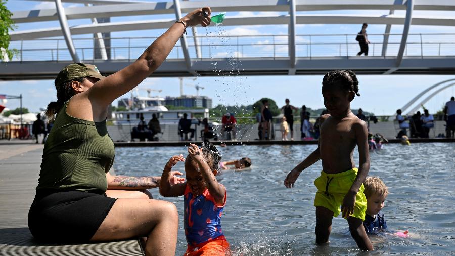 Deonna Owens brinca com seus filhos na piscina infantil do Yards Park em meio a uma onda de calor em Washington, EUA, 19 de junho de 2024