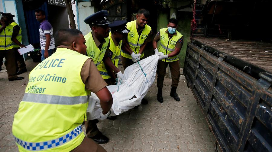 Policiais carregam o corpo de uma das vítimas do tiroteio entre tropas do Sri Lanka e grupo armado suspeito de estar envolvido nos ataques ocorridos na Páscoa - Dinuka Liyanawatte/Reuters