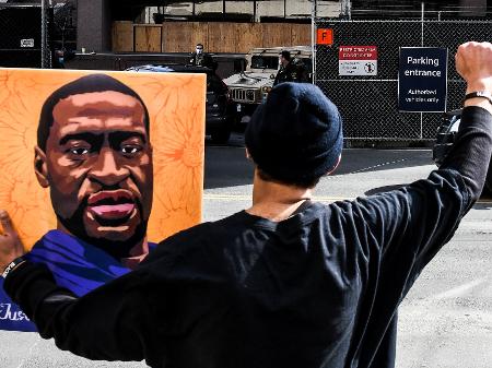 9.mar.2021 - Manifestante segura retrato de George Floyd em frente ao tribunal onde o caso é julgado em Minneapolis (EUA) - Chandan Khanna/AFP