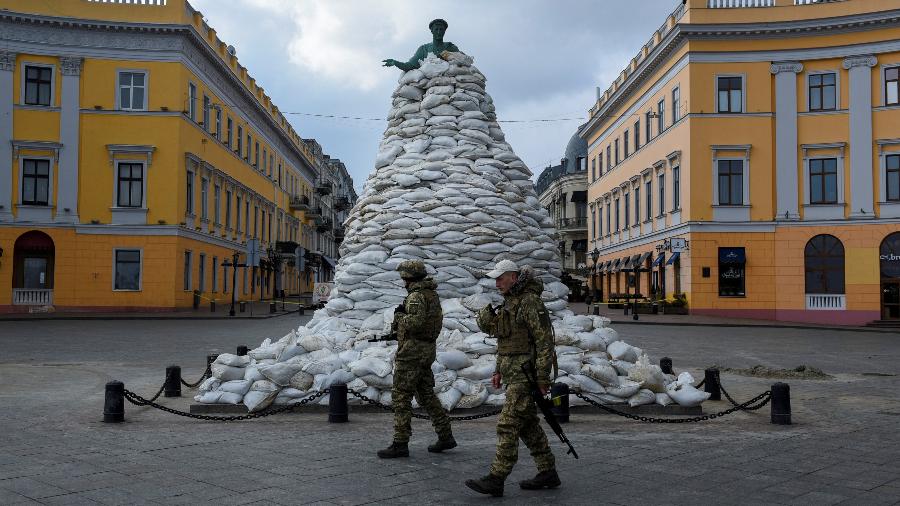 10.mar.2022 - Soldados caminham por monumento coberto por sacos de areia em Odessa, na Ucrânia, em meio à invasão da Rússia - Alexandros Avramidis/Reuters
