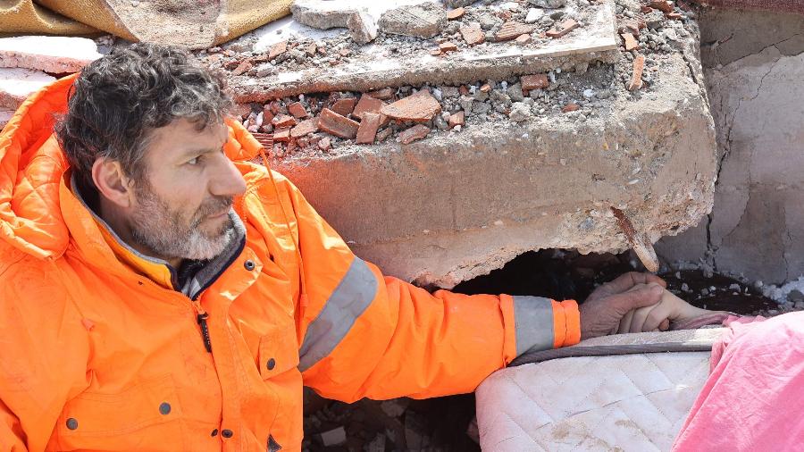 Mesut Hancer segurou a mão de Irmak, sua filha de 15 anos de idade, que morreu em um terremoto em Kahramanmaras, na Turquia - 7.fev.2023 - Adem Altan/AFP