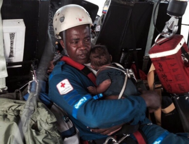 Integrante da Cruz Vermelha segura bebê de um ano que ficou perdido com sua mãe por uma semana na selva colombiana após a queda do helicóptero onde estavam - Força Aérea Colombiana/EFE