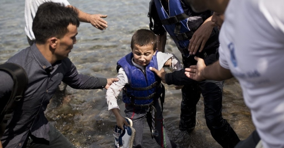 9.set.2015 - Menino afegão chora após chegar às margens da ilha grega de Lesbos, depois de cruzar o mar Egeu, vindo da Turquia, em um bote