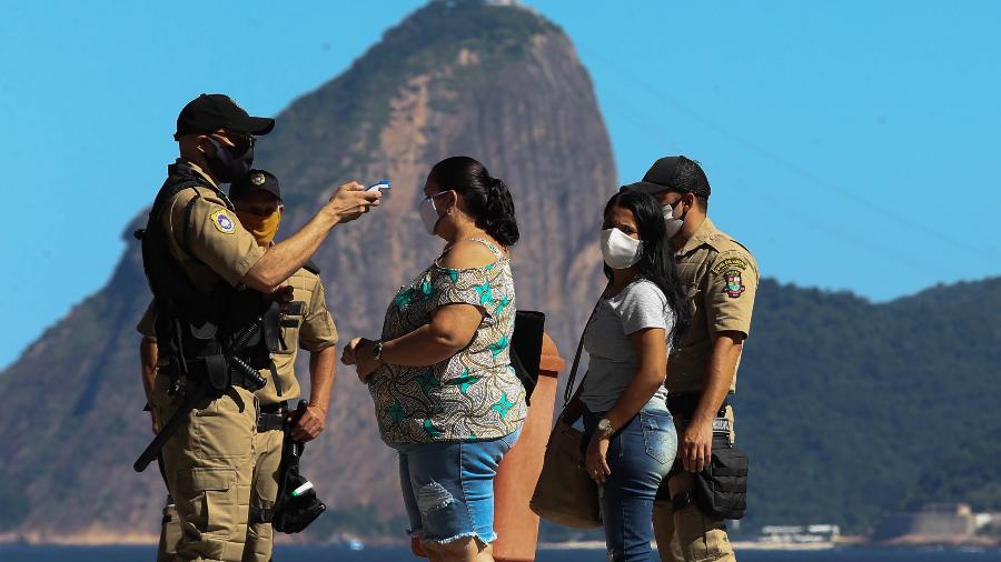 11/05/2020 - Coronavírus: Guardas municipais medem a temperatura de pedestres na praia de Icaraí, no primeiro dia de lockdown em Niterói (RJ) - Wilton Junior/Estadão Conteúdo