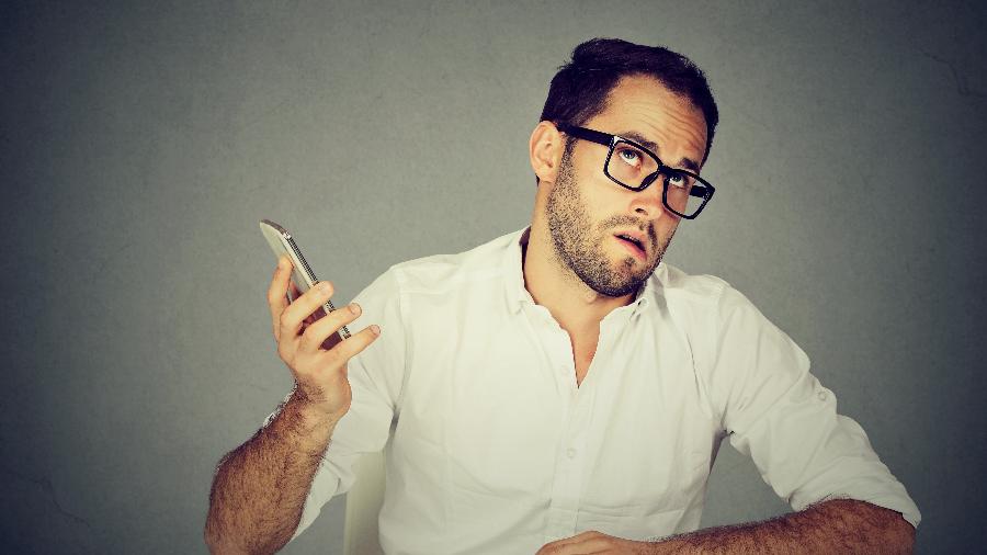 Imagem representativa de homem impaciente segurando o celular - Getty Images