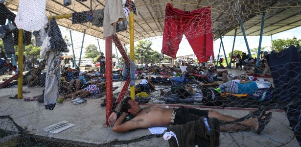 Migrantes hondurenhos que participam da caravana em direção aos EUA descansam em um acampamento improvisado em Huixtla, estado de Chiapas, no México - PEDRO PARDO/AFP
