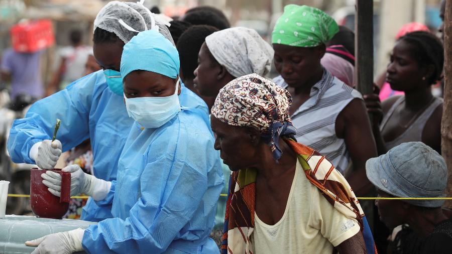27.mar.2019 - Equipe médica mistura uma solução de cloro para distribuição num centro de saúde que lida com doenças transmitidas pela água na Beira, Moçambique - Mike Hutchings/Reuters
