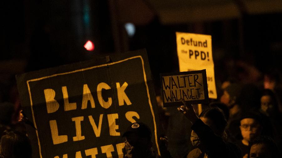 27.out.2020 - Manifestantes seguram cartazes em protesto pela morte de Walter Wallace Jr. na Filadélfia - Mark Makela/Getty Images/AFP